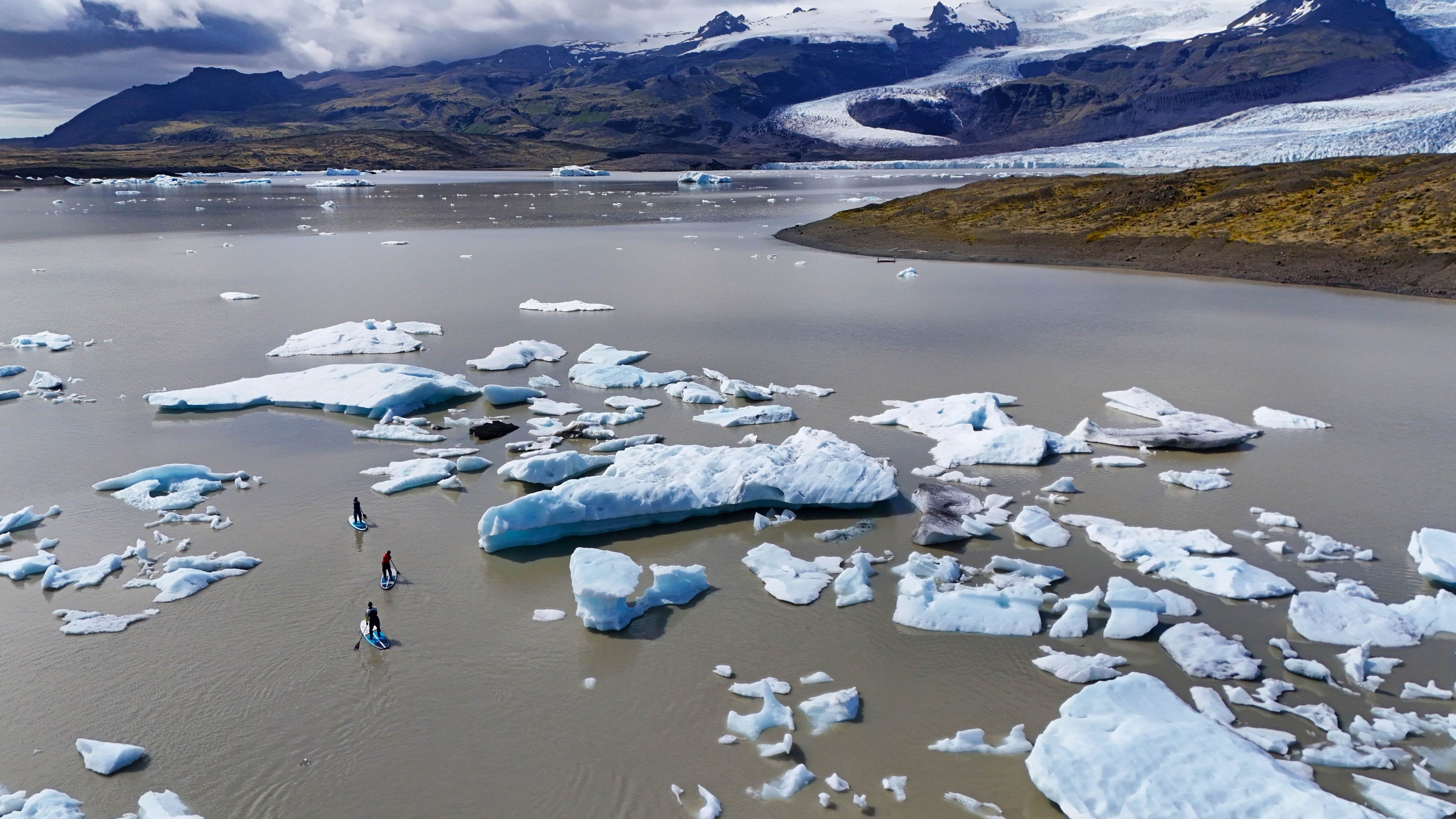 Mother, daughter and son stand up paddle board through the icebergs of Iceland in Mustang Survival Hudson and Helix drysuits