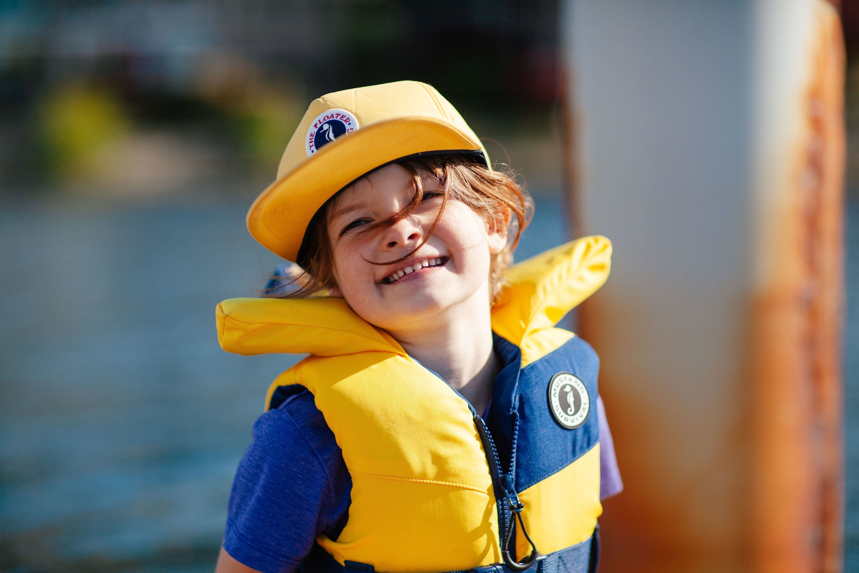 Child on the dock wearing Lil Legends PFD with head pillow and crotch strap for maximum safety on the water