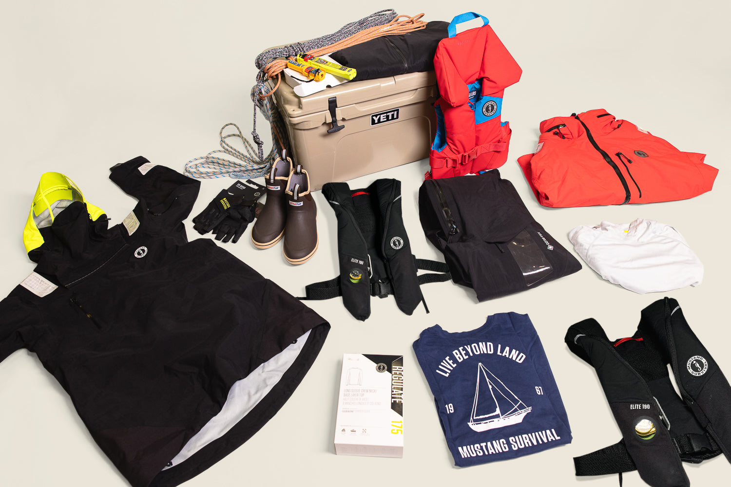 Mustang Survival sailing gear laid out for holiday gift ideas, including PFDs, sailing jacket, and accessories.