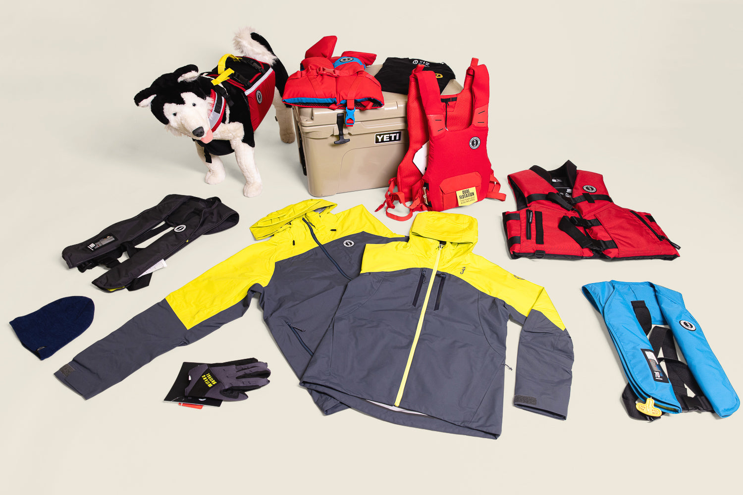 Mustang Survival gear laid out for holiday gifts for boaters, featuring Taku jackets, PFDs, and accessories.