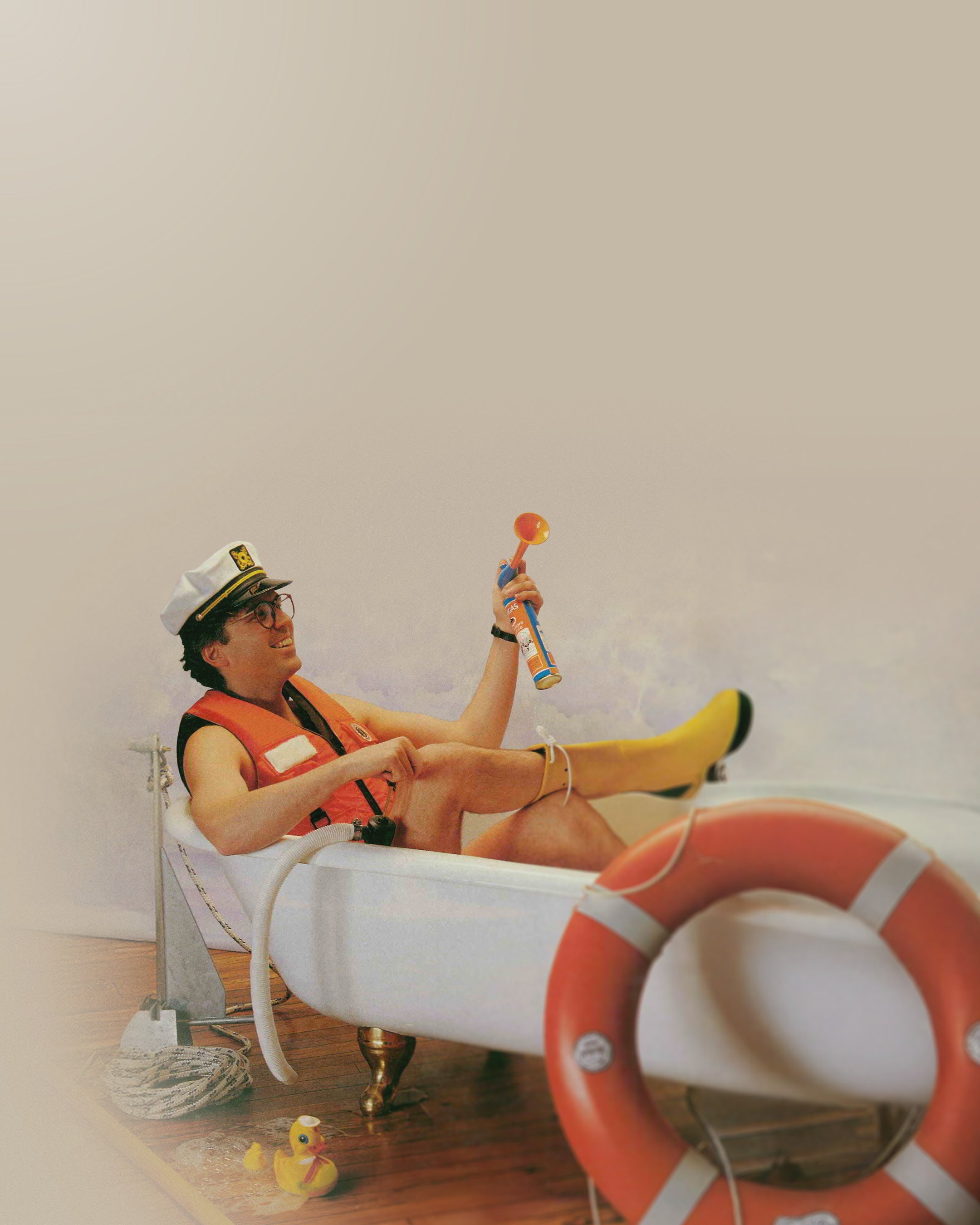 Person in a life jacket and captain's hat sitting on an bath tube with a white background